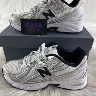 Sapatilhas New Balance brancas com detalhes em preto sobre caixa cinzenta e cartão RAFA STORE.