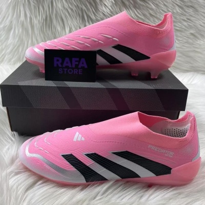 Chuteiras de futebol rosa com detalhes pretos e brancos sobre superfície branca fofa.