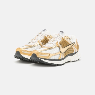 Ténis Nike Vomero 5 branco e dourado com sola preta e branca