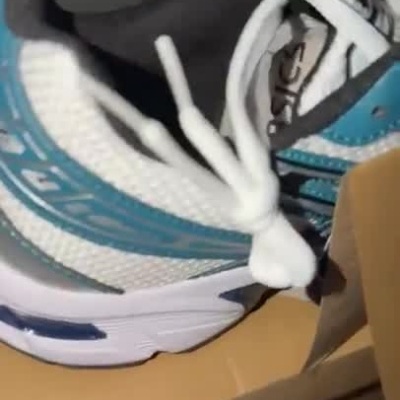 Sapatilhas Asics azul e branco com etiqueta sobre caixa