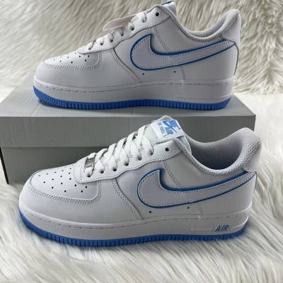 Par de sapatilhas Nike Air Force 1 em pele branca com detalhes azuis sobre caixa cinzenta