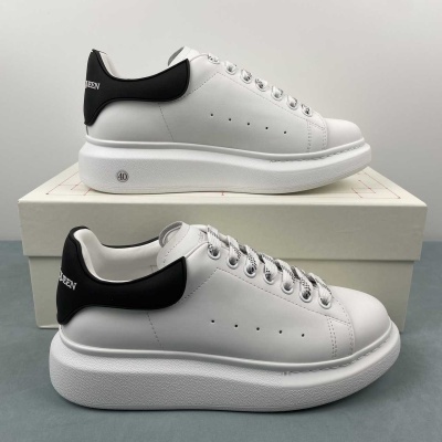 Par de sapatilhas brancas com detalhe preto no calcanhar e sola espessa