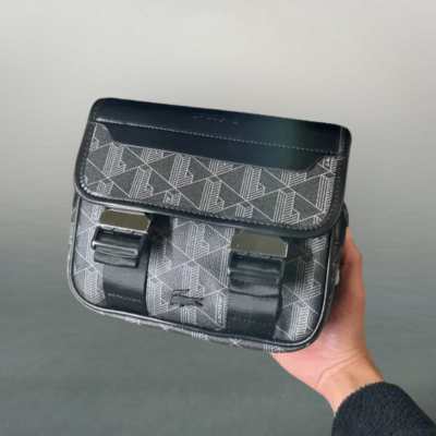 Mala pequena preta com padrão geométrico branco e fechos metálicos