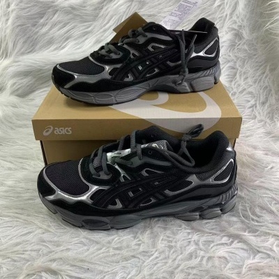 Sapatilhas desportivas pretas e cinzentas ASICS sobre caixa e tecido branco felpudo