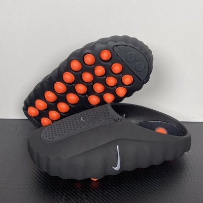 Chinelos pretos da Nike com sola preta e bolhas vermelhas na parte inferior