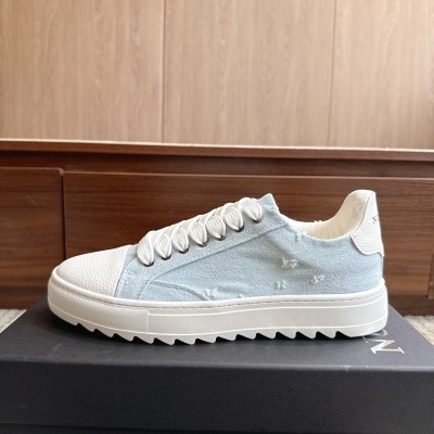 Ténis azul claro e branco com atacadores brancos sobre caixa preta