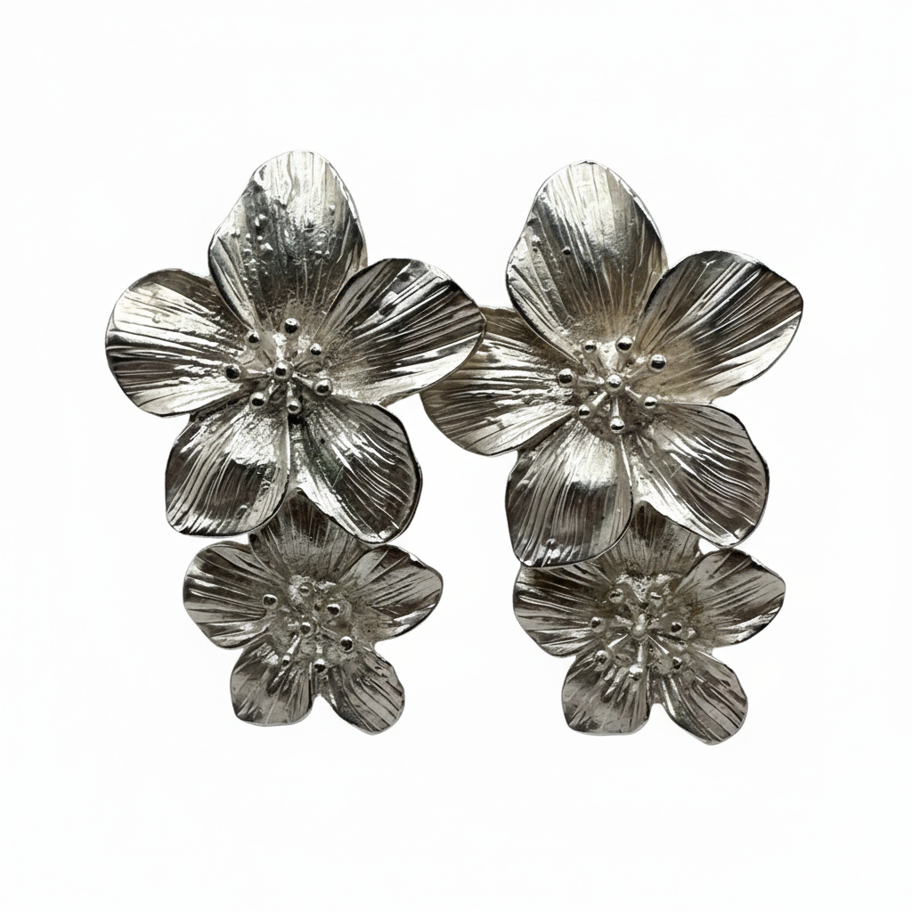 Brincos em aço prateado com flores esculpidas Brincos metálicos prateados em forma de flores com detalhes texturizados