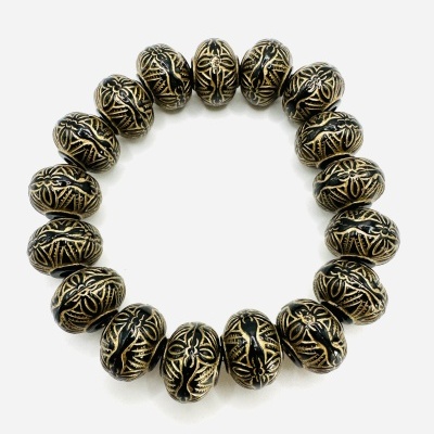 Pulseira com contas metálicas douradas e pretas com padrão trançado