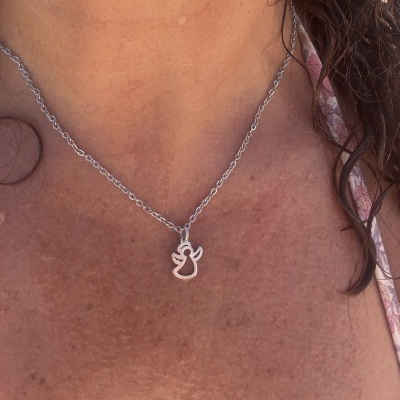 Colar prateado com pendente de gato estilizado ao pescoço