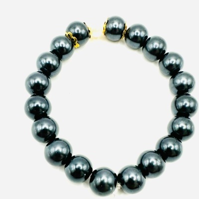 Pulseira de esferas pretas brilhantes com detalhes dourados em fundo branco