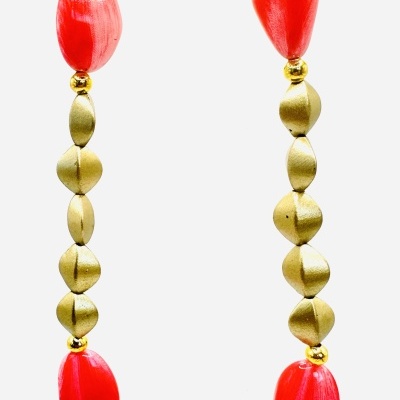 Colar com contas vermelhas e douradas em fundo branco