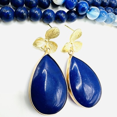 Brincos azuis em gota com detalhes dourados e colares de contas azuis