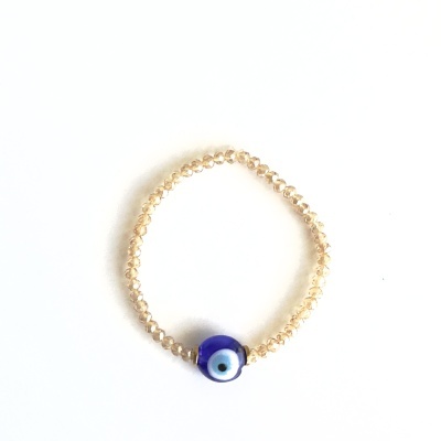 Pulseira com contas pequenas bege e conta azul com desenho de olho