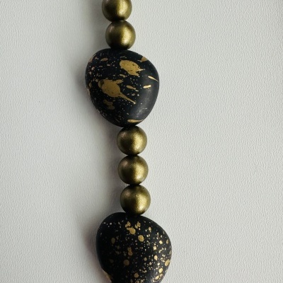 Colar com contas pretas salpicadas de dourado e esferas metálicas douradas