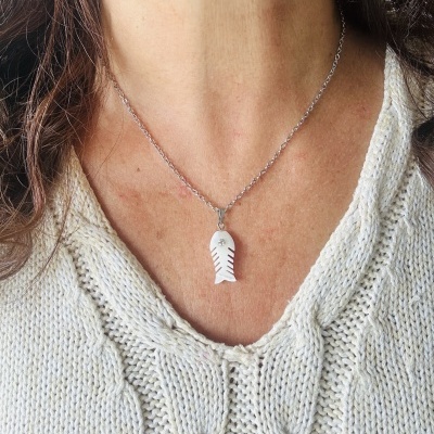 Colar prateado com pendente branco em forma de espinha de peixe e camisola branca de malha