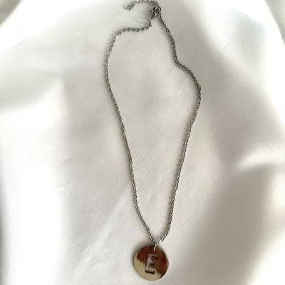 Colar com pendente redondo prateado e letra E recortada