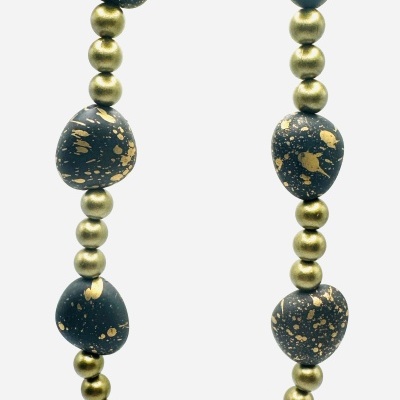 Colar com contas preto e dourado em fundo branco