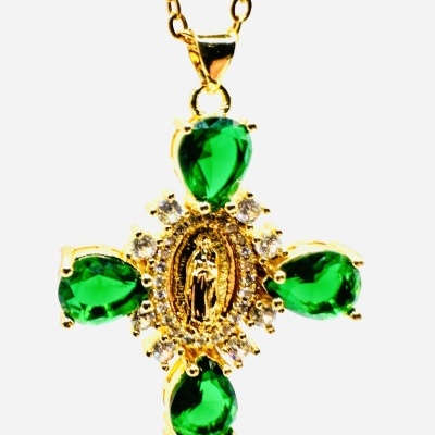 Colar dourado com pendente em forma de cruz com pedras verdes e cristais brancos