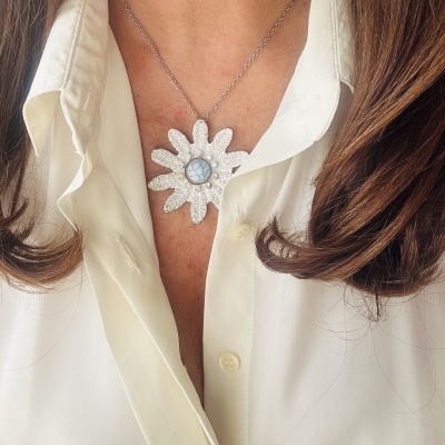 Colar com pendente de flor branca e centro azul marmoreado com corrente prateada