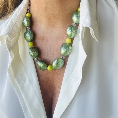 Colar verde e amarelo marmoreado usado sobre camisa branca aberta