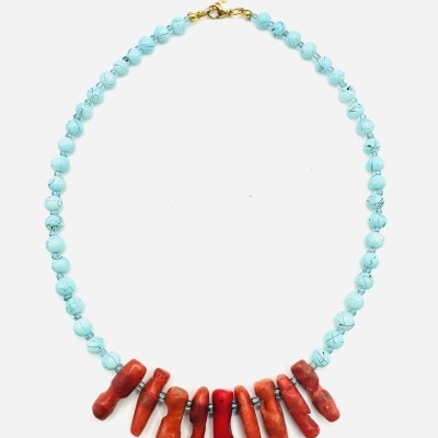 Colar com contas azuis claras e pendentes vermelhos e alaranjados, fecho dourado