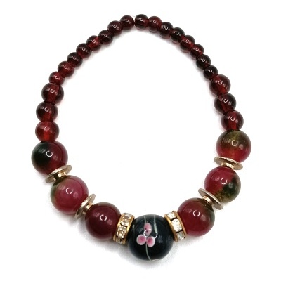 Colar de contas vermelhas, verdes e esfera central preta com flores