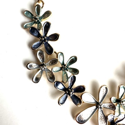 Colar floral metálico esmaltado em azul, verde e branco com fundo branco