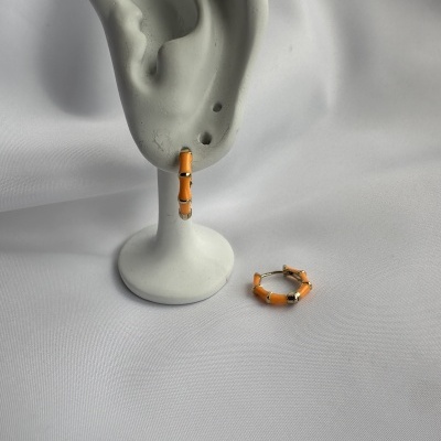 Brincos de argola pequenos laranja com detalhes dourados em suporte branco
