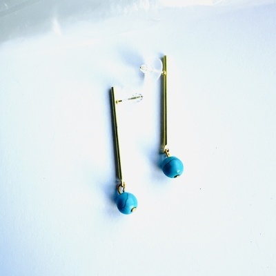 brincos dourados com bola azul turquesa sobre fundo branco
