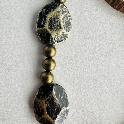 Colar com contas marmorizadas pretas e bege e contas douradas esféricas