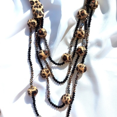 Colar com contas forradas padrão leopardo e contas brilhantes pretas e castanhas sobre tecido branco