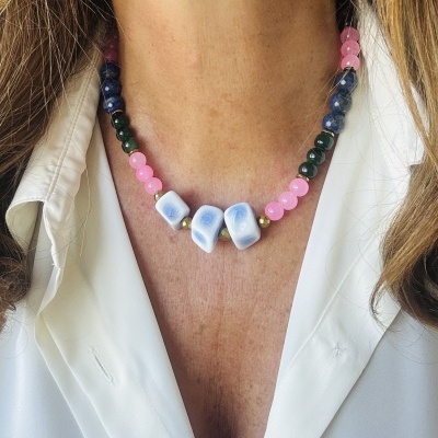 Colar de contas coloridas com pedras azuis claras e folhas