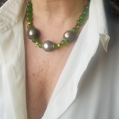 Colar com contas verdes e contas grandes decoradas usado com camisa branca