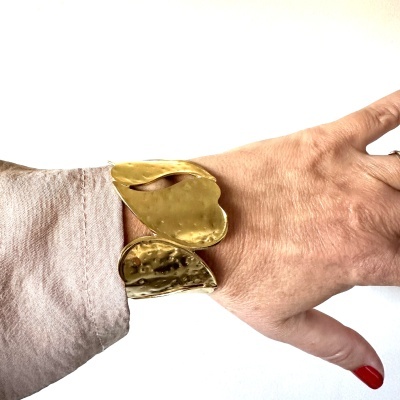 Pulseira dourada martelada com design orgânico no pulso