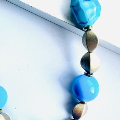 Colar com contas azuis e elos metálicos dourados