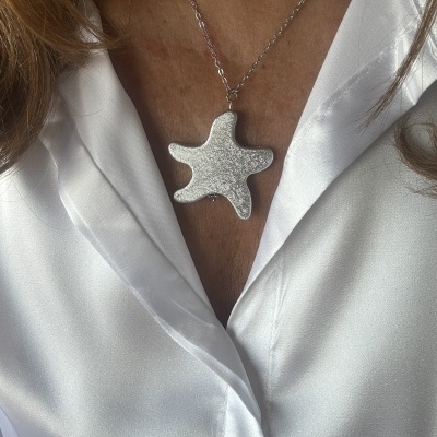 Colar com pendente em forma de estrela do mar prateado e camisa branca acetinada