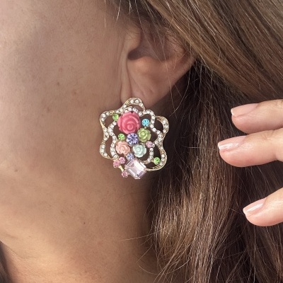 Brinco dourado em forma de flor com pedras coloridas e pequenas flores decorativas.