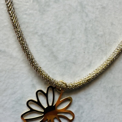 Colar prateado com pendente em forma de flor dourada