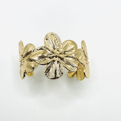 Anel dourado com flores texturizadas em fundo branco