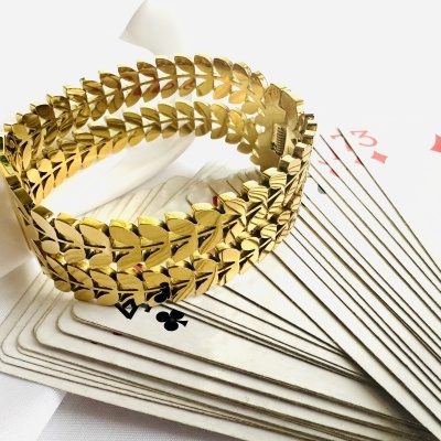 Pulseira dourada sobre cartas de baralho abertas