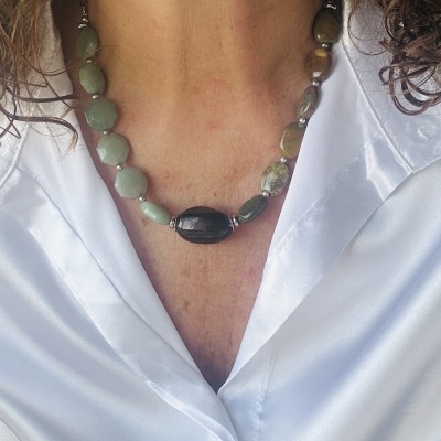 Colar de pedras verdes e preta, usado com camisa branca de cetim