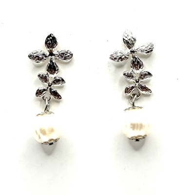 Brincos prateados com flores e pérolas sobre fundo branco