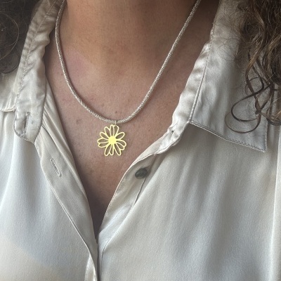 Colar prateado com pendente flor dourada e camisa branca