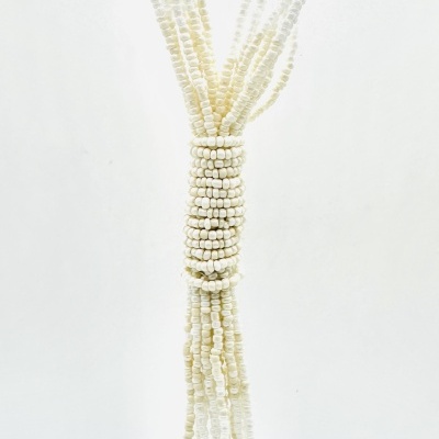 Colar comprido com contas brancas e douradas e nó central com franjas
