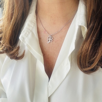 Colar prateado com pendente em trevo de quatro folhas e camisa branca