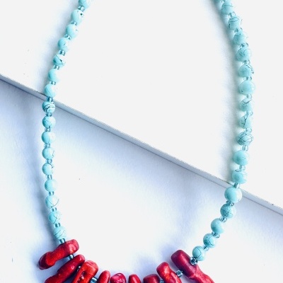 Colar azul com pendentes vermelhos em coral.
