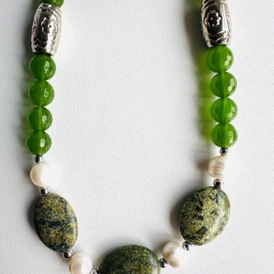 colar com contas verdes, prateadas e brancas sobre fundo branco