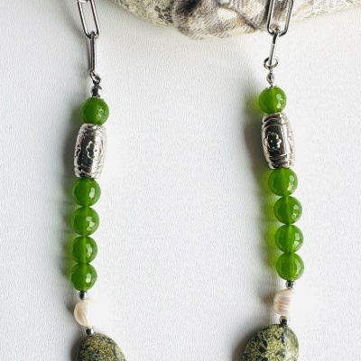 Colar com contas verdes e pedras naturais em fundo branco com tecido