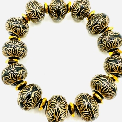 Pulseira de contas metálicas douradas e pretas com padrões gravados