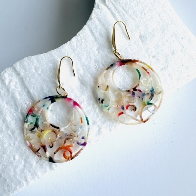 Brincos redondos em resina transparente com padrões coloridos e gancho dourado